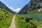 Path through spring mountains landscape near alpine lake. Stillup, Stillup Lake, Austria