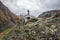 Path to ancient medieval monument in mountains of Caucasus. Christian cross in touristic place