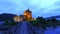 Path to illuminated Eilean Donan Castle over the lake in Scotland, UK