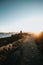 Path to the red lighthouse under a massive sunset in the coastline of spain during a super bright day