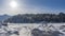 The path is trampled in the snow. Steam rises above the thaw in the frozen river.