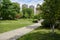 Paths in grassy lawn before multi-story apartments at sunny summer noon