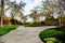 Pathway along manicured lawn with flowers and trees