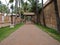 Pathway in  the middle of buildings and palm trees with a person in the distance