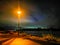 Pathway at night at the riverside of the river Rhein in Cologne with sand beach and moody autum sky