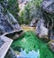 Pathway on the rocky hill in Parrizal Beceite, Spain, and a transparent and reflective water surface