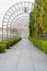 Pathway with trees tunnel and buildings, Singapore City. Way through garden park in summer season. Natural landscape background