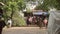 Pathway view to village road nearby ferry boat landing area and people returning home with shopping bags on foot, by bicycle 