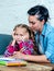 Patience mum with daughter unable to concentrate whilst doing homework sitting on sofa at home in learning difficulties homework