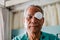 Patient covering eye with protective shield after eyes cataract surgery in hospital