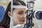 Patient on diagnostic of vision, oculist cabinet. Optician measuring a woman`s eyesight. Young woman visiting ophthalmologist in