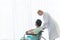 Patient elderly man is sitting in a wheelchair with Physiotherapist standing behind happy and smiling