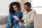 Patient and nurse sitting on sofa while watching movie on tablet