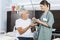 Patient Receiving Water Glass And Pill From Female Nurse