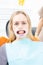 Patient with retractor in dentist office looking at camera