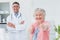 Patient showing thumbs up sign while standing with doctor