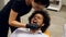 A patient sitting in a dentists chair and waiting for the dentists assistant to determine the right shade color of his teeth