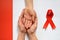 Patient support with diagnosis of HIV AIDS. Womens hands holding hand. World Aids Day and red ribbon. Bad news.