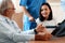 Patient in wheelchair discuss her health with doctor in sterile room.