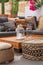 Patio of a Mediterranean villa with cacti and bougainvillea, low wooden coffee table with large glass vessels