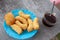 Patonggo on a blue plastic plate and black coffee on a wooden background