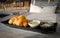 Patonggo or deep-fried dough sticks on black dish with pandan and sweet condense milk dipping on table