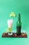 Patrick day, fresh foamy beer in a glass, chips and crackers on a wooden board, shamrock on a green background