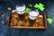 Patrick`s Day, foamy beer in glass mugs and a bottle, crackers, gold coins and a green shamrock on a wooden background