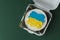 Patriotic cake decorated with yellow and blue Ukrainian flag. Small trendy bento cake in the white gift box. Korean style little