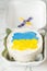 Patriotic cake decorated with yellow and blue Ukrainian flag. Small trendy bento cake in the white gift box. Korean style little