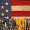 Patriotic collection of old and used work tools on worn US American flag. Made in USA, American workforce, or Labor Day