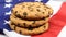 Patriotic cookies. Three rounded traditional chocolate chip cookies on the background of the flag of the United States of America