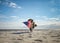 Patriotic dog running along the beach carrying the American flag