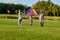 Patriotic family running with huge american flag.