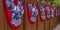 Patriotic flags hung on a wooden fence by sidewalk