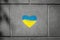 A patriotic heart in the colors of the flag of Ukraine on the sidewalk, drawn with crayons in two colors of yellow and