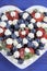 Patriotic red, white and blue berries with fresh whipped cream stars - vertical close up.