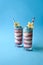 Patriotic smoothie glasses with blue spirulina, strawberry and vanilla smoothies on blue background