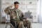 Patriotic veteran sitting in wheelchair, using laptop
