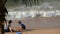 Pattaya, Thailand - December 25, 2017: Little boy in a swimming suit makes something of sand with his mother. Beach with