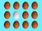 Pattern of brown white chicken eggs isolated on blue pastel background. Top view