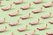 Pattern created from fresh exotic dragon fruit slices on brigh green background