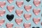 Pattern created of many pink heart and two black heart shaped balloons. Blue background. Diversity and black lives matters