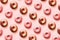 Pattern of d onuts with icing and chocolate on pastel pink background.Sweet donuts