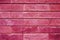 pattern of decorative pink slate stone wall surface as a background. toned in viva magenta, trend color