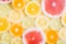 Pattern of different sliced citrus fruits on yellow background. Out of focus, water drops texture