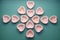 Pattern of empty tartlets in the shape of hearts. Green background. Preparation for the holiday. Molds for filling with sweets or