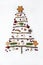 The pattern in the form of a Christmas tree is made of branches and decorated with hawthorn berries, gingerbread, wooden toys on a