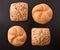 Pattern of four loaves on black wooden table top