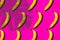 Pattern of fresh yellow bananas under the shade of banana leaves on pink background with copy space for your text.